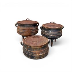 Three South African cast iron graduating cooking pots with lids and handles. Size shown for the largest