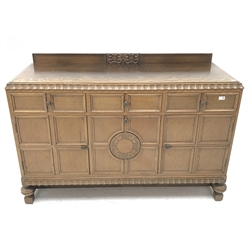E. Gomme Ltd of High Wycombe oak sideboard, raised carved back, moulded top, three drawers above two cupboards flanking single fall front unit, turned supports joined by stretchers, W150cm, H101cm, D57cm