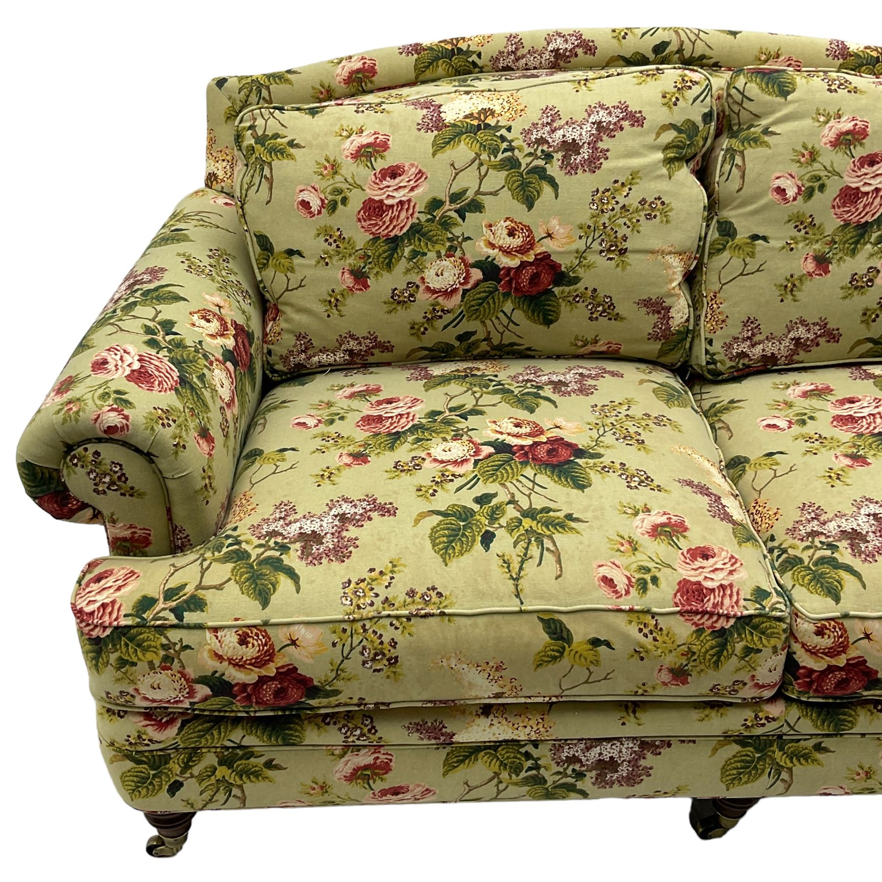 Hancock & Moore - two-seat sofa, upholstered in pale green ground fabric decorated with floral pattern, traditional shape with rolled arms and arched back, on turned front feet with brass cups and castors 