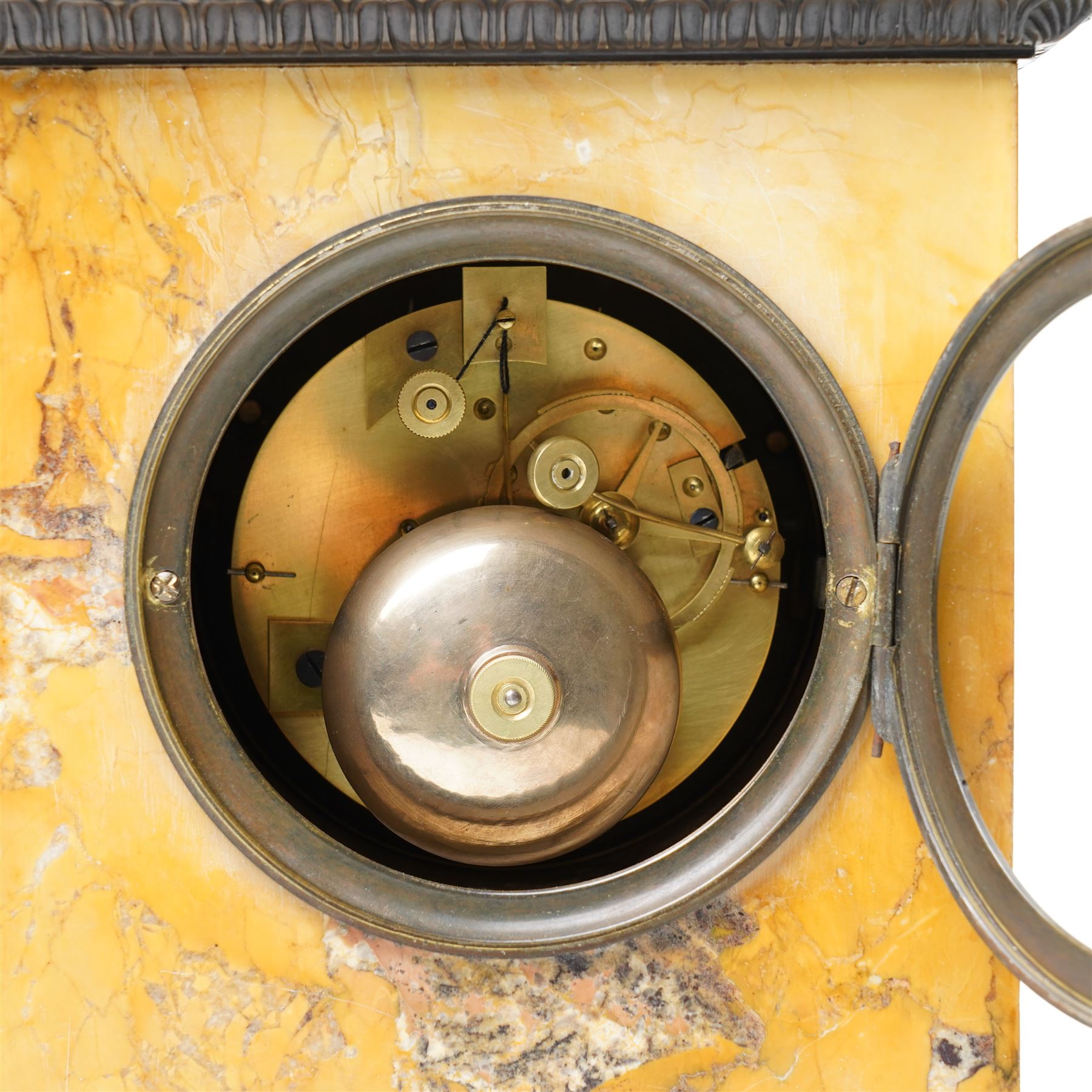 French-First quarter 19th century 8-day sienna marble and bronze-mounted mantel clock of rectangular architectural form, with patinated foliate guilloche pattern cast bronze mounts  in richly figured sienna marble, surmounted a by a classical patinated bronze bust of Napoleon Bonaparte, above a gilt engine turned dial with Roman numerals and blued steel hands, with a twin train Parisian countwheel striking movement, striking the hours and half-hours on a bell, silk suspension with thumb-screw adjustment. With pendulum.