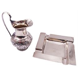 Edwardian silver cream jug, of baluster form with curved handle, the body embossed with scrolls, hallmarked Birmingham 1904, makers mark indistinct, possibly CH, including handle H11cm, together with a 1930's silver ashtray, of square form with four rests to engine turned rim, hallmarked Clark & Sewell, Birmingham 1939, W11.5cm, approximate total weight 6.57 ozt (204.5 grams)