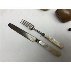 Swiss mountain hunters tobacco pipe with a horn mouthpiece, metal hinged pierced lid and brass chain, the black coated body adorned with small metal cow flowers, together with two other pipes and case, brass mounted horn, brass mounted bone box, carved mother of pearl handled knife and fork and brass jug