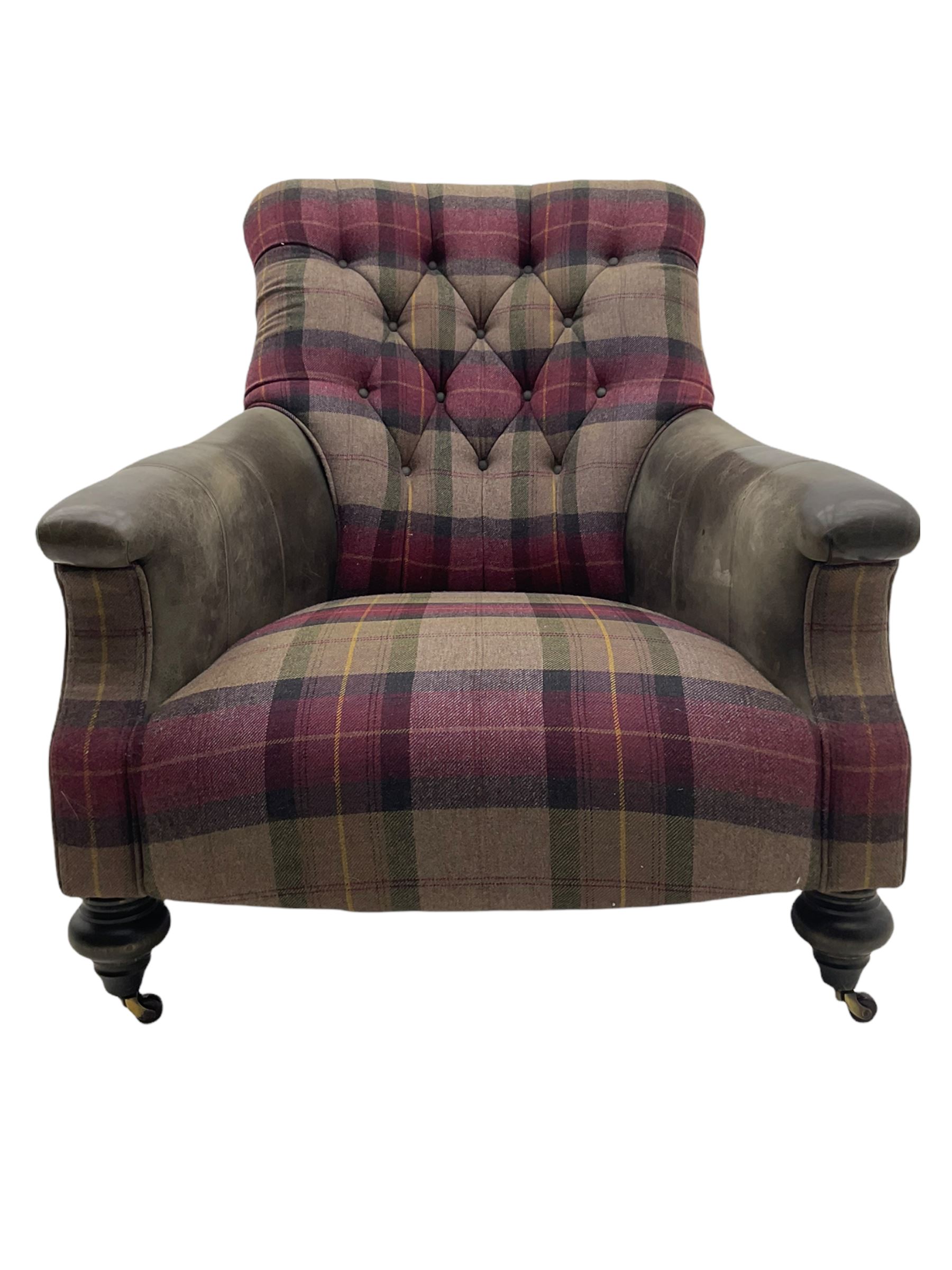 John Sankey - low armchair, buttoned back upholstered in tartan patterned fabric with contrasting grey leather, raised on turned and ebonised front feet with brass and ceramic castors, with matching foot stool