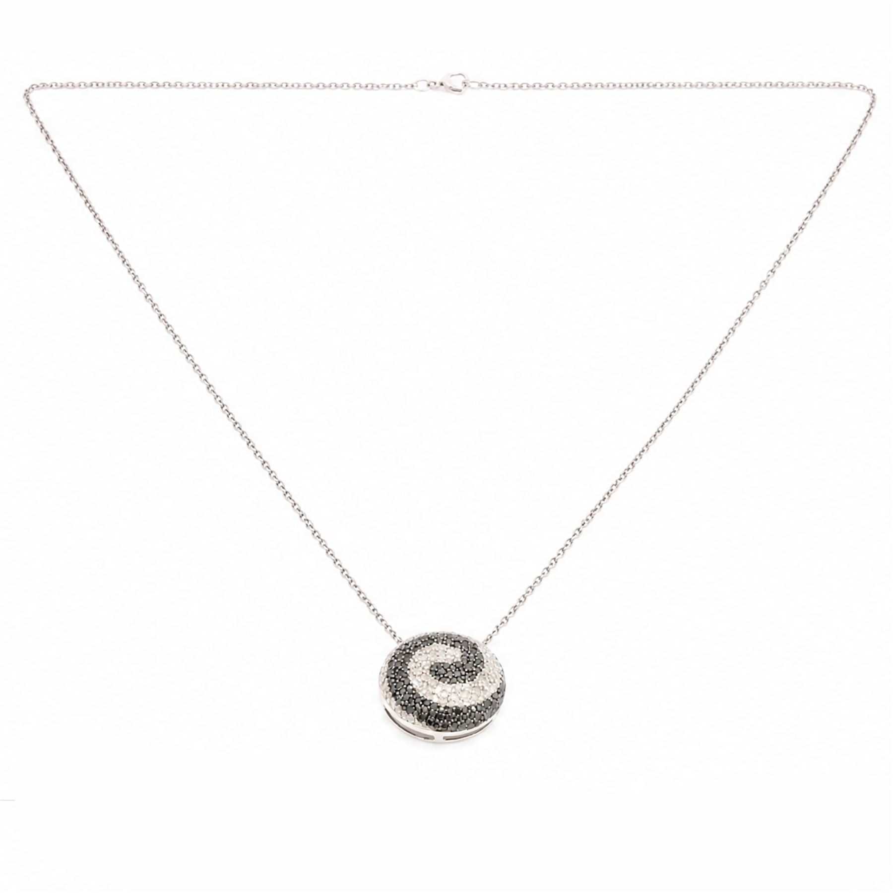 9ct white gold diamond swirl pendant necklace, circular pendant pave set with black and white diamonds, on a fine trace link chain necklace, both hallmarked, total diamond weight approx 1.55 carat