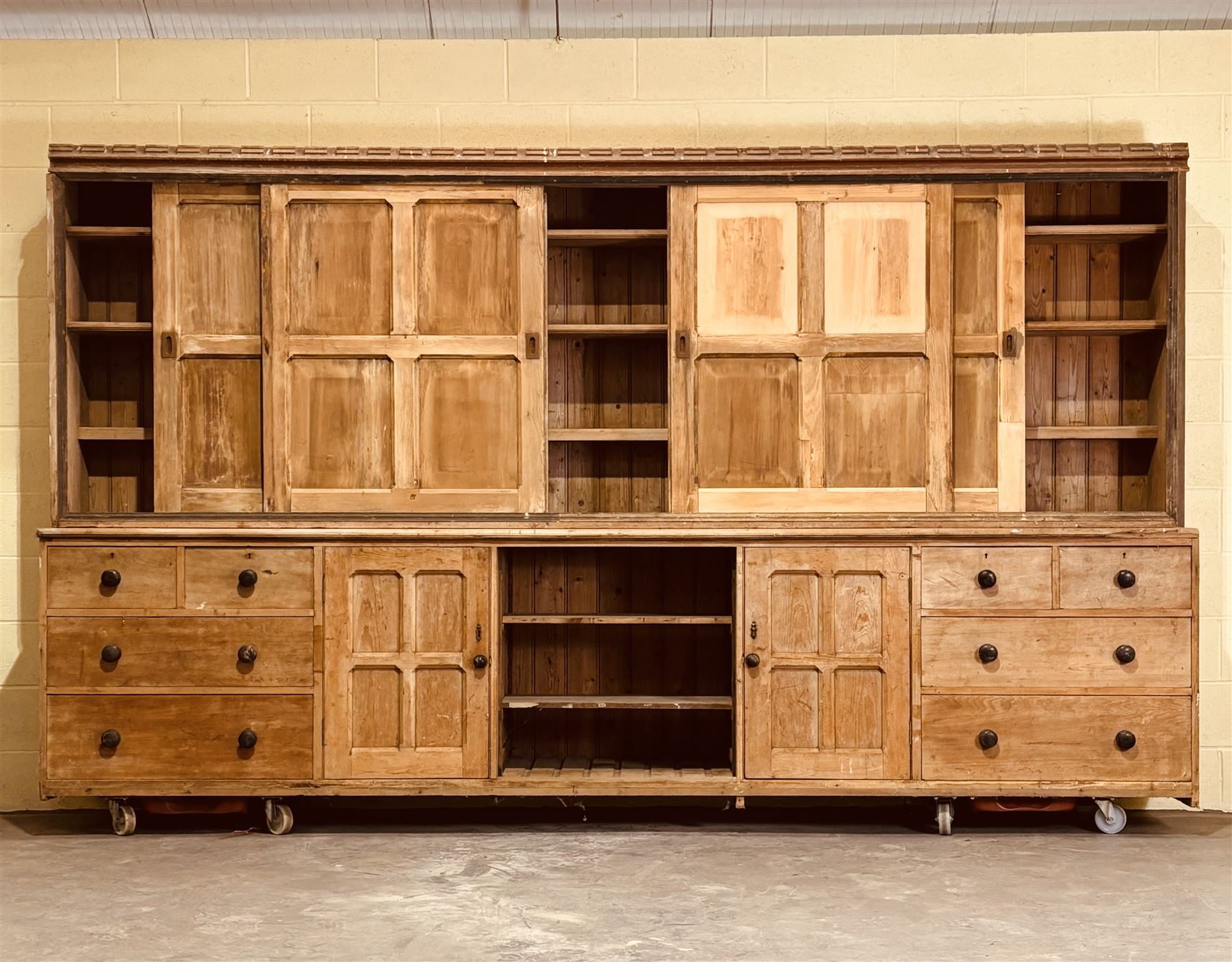 Late Victorian country house pine dresser, the four fielded panelled sliding cupboard doors opening to reveal three shelves, over a base fitted with two adjustable shelves to centre, flanked at each end with a cupboard, two short, and two long drawers, restoration and later elements. H218cm, L375cm, D62cm. - COLLECTION BY APPOINTMENT FROM: The White House, Thirsk Road, Easingwold, York, YO61 3NF - CALL 01723 507111 TO ARRANGE