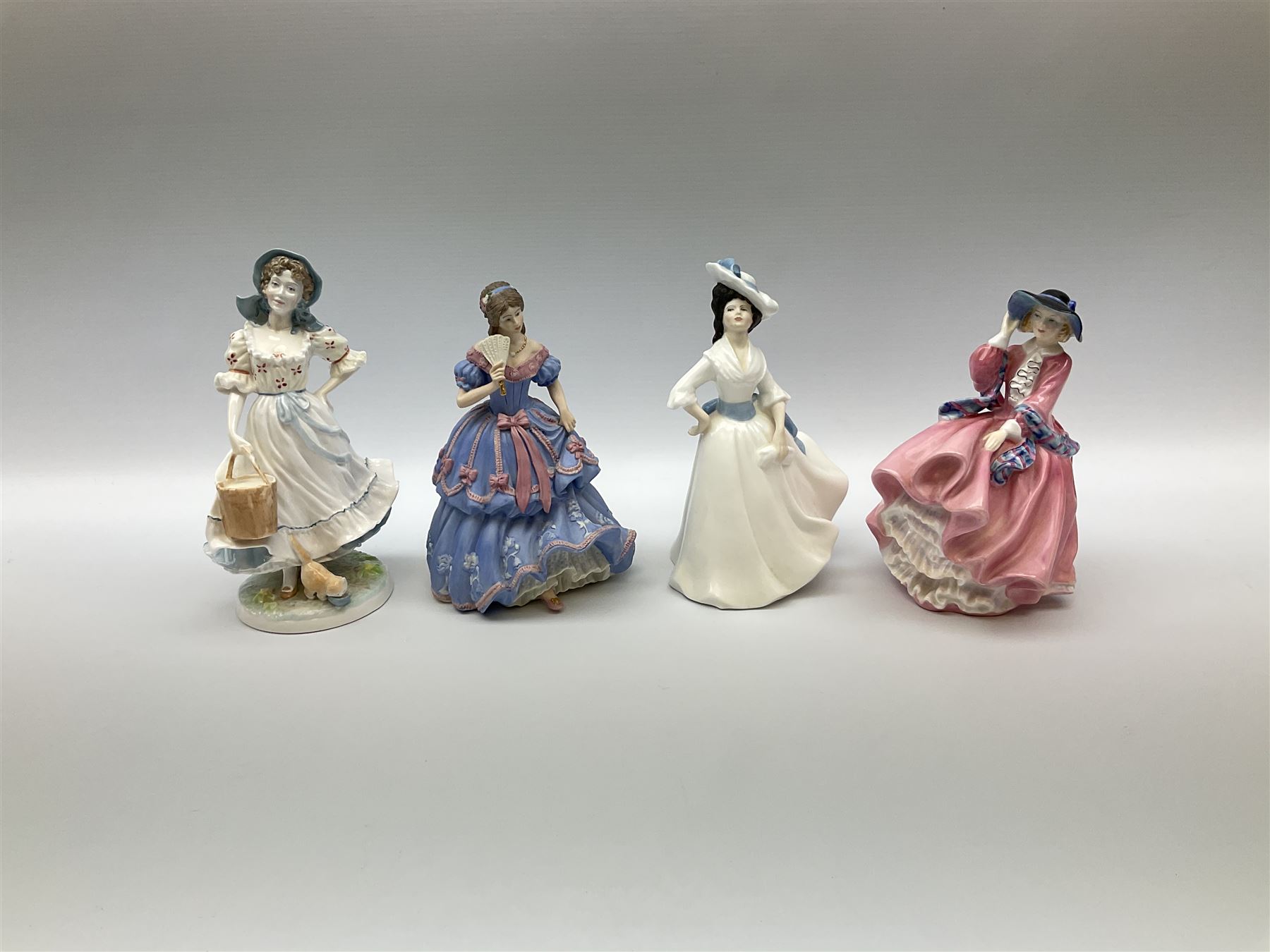 A group of figures, comprising four Royal Worcester examples, The Milkmaid, Lady Emma, Lady Cicely, Lady Hannah, three Royal Doulton examples, Top o' the Hill HN1849, Margaret HN2397, Fair Lady HN3216, two Coalport examples Fairest Flowers Heather, and Pansy, and a Wedgwood figure commissioned by Spink, The Imperial Banquet. 