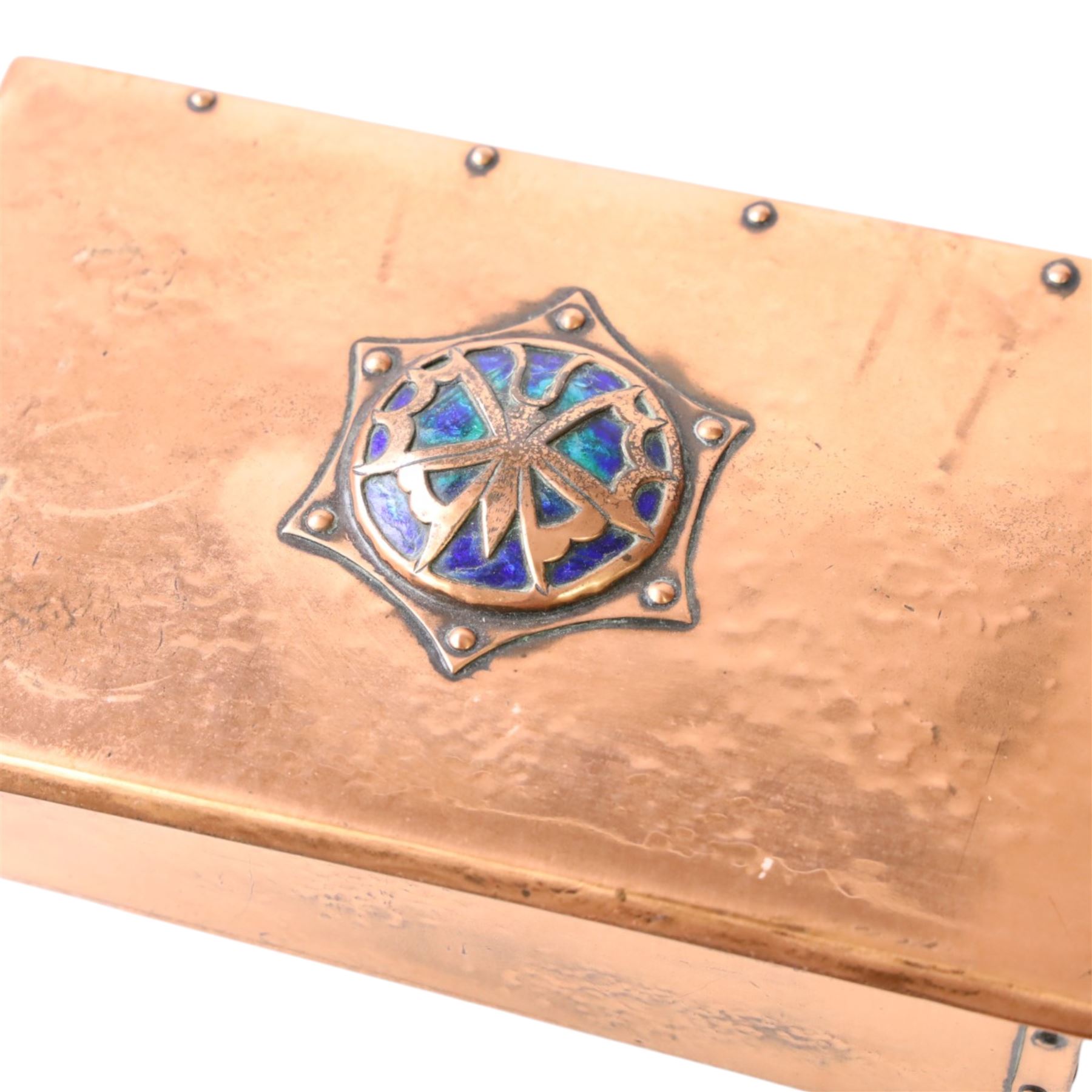  Arts & Crafts copper and enamel box, of rectangular form, the hinged lid with central enamel cabochon overlaid with pierced copper butterfly motif, raised on brass bun feet, H7cm, L17cm