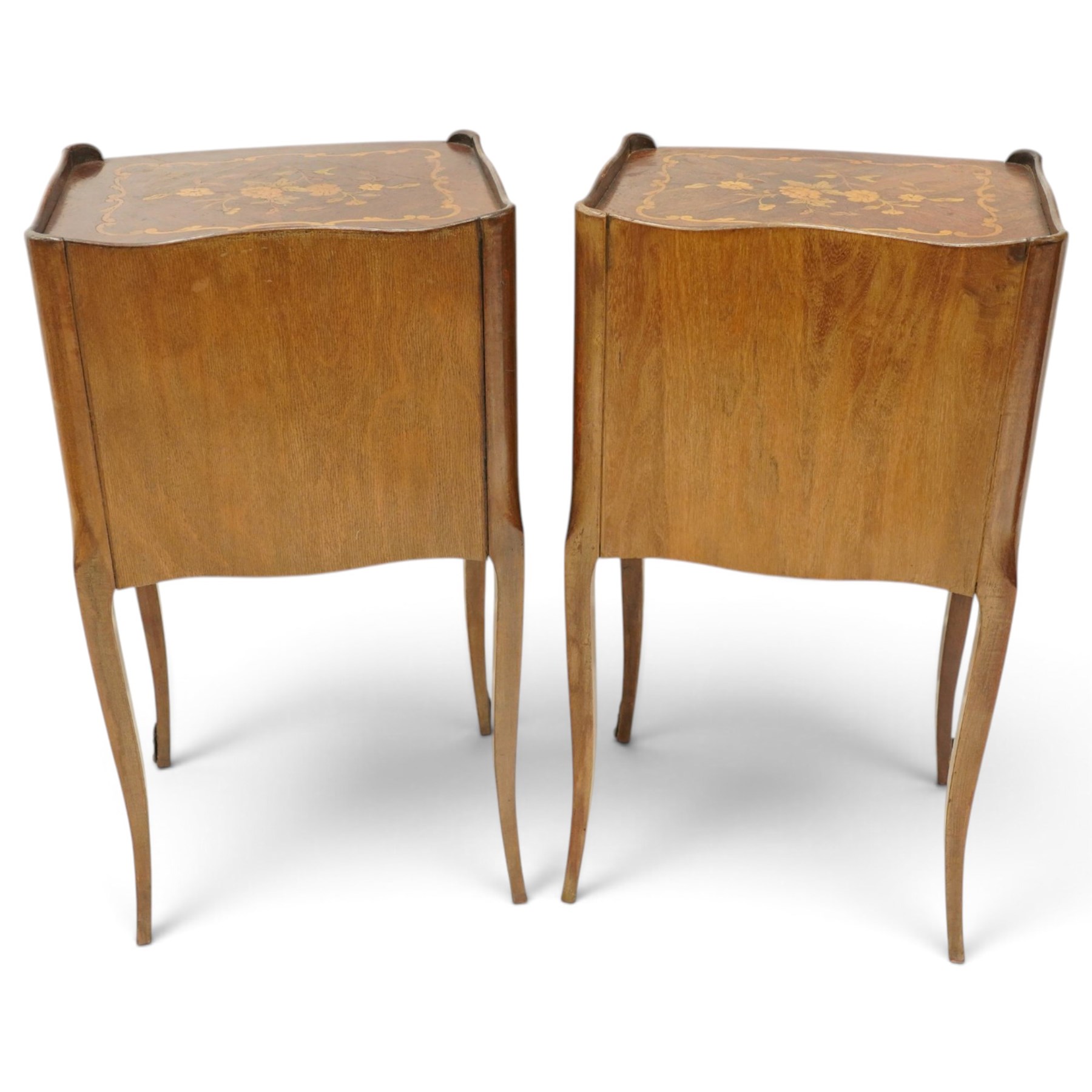 Matched pair of French inlaid floral marquetry bedsides, the three-quarter gallery tray top with central floral bouquet inlay and C-scroll border, one fitted with single frieze drawer over recessed cupboard and shaped apron, the other with three drawers, raised on tapering cabriole supports, with brass cartouche feet