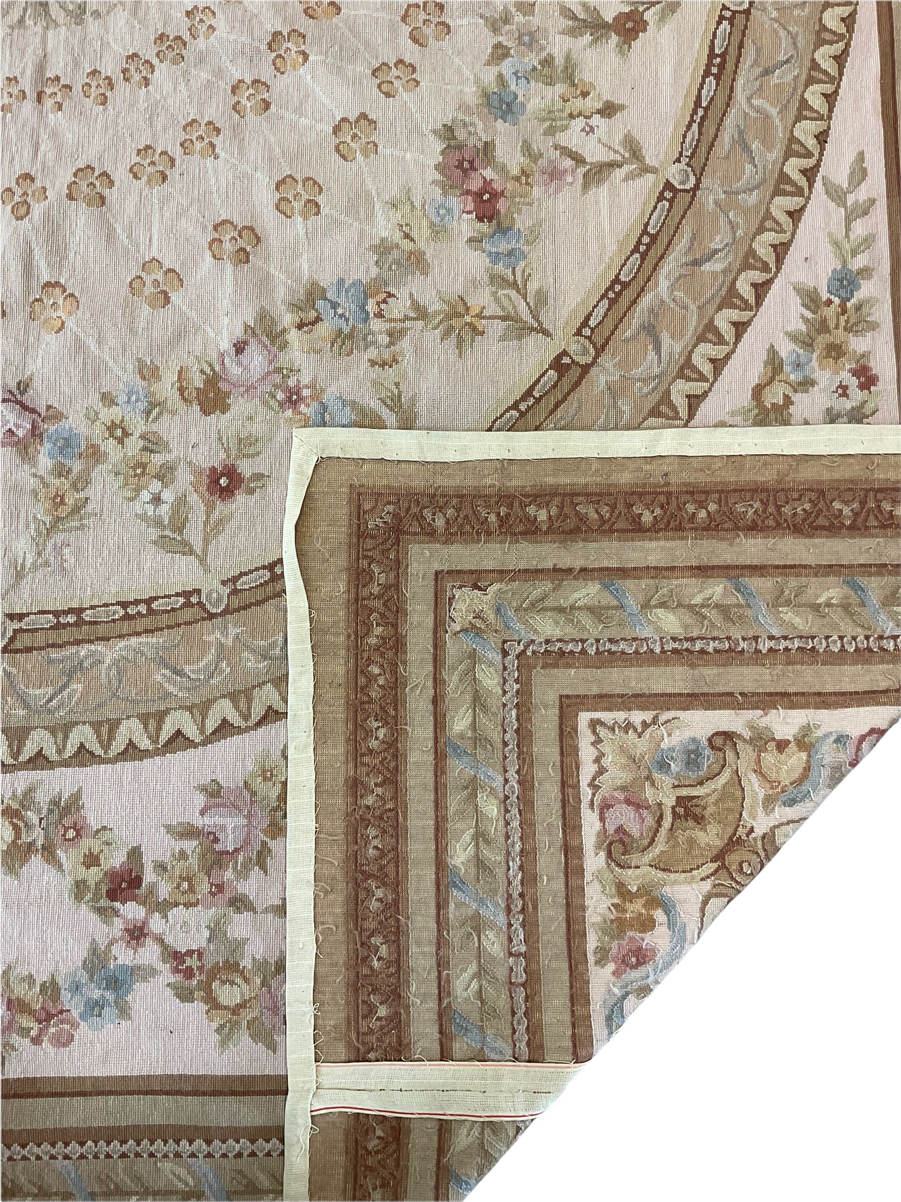 Late 20th century French style needle work Aubusson rug, circular field decorated with floral garlands and flower head motifs, multi-band border