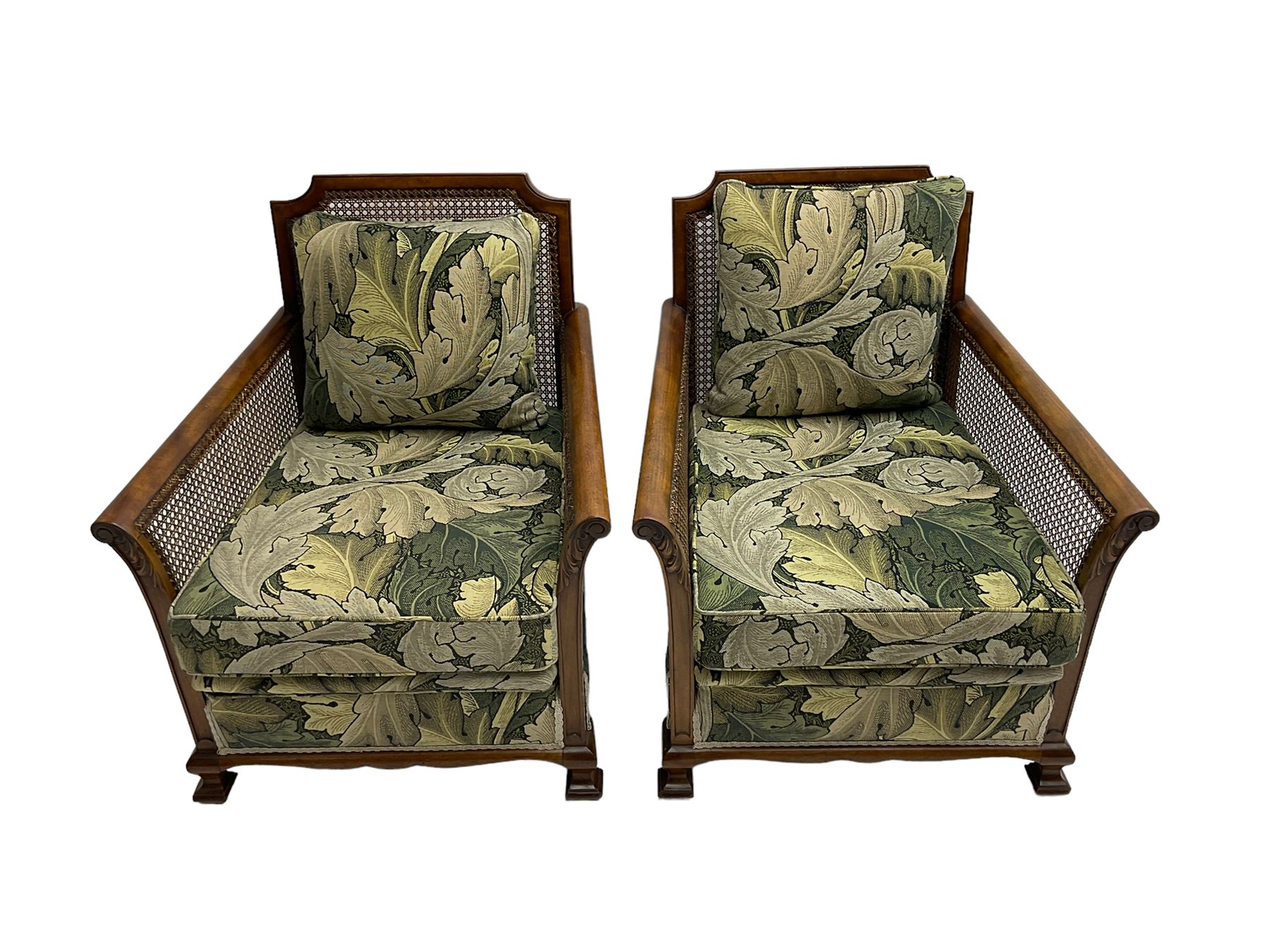 Early 20th century bergère lounge suite, mahogany framed with cane work back and sides, acanthus scroll carved uprights - three seat sofa (W167cm, H82cm, D83cm), and pair matching armchairs (W78cm), loose cushions upholstered in acanthus leaf scroll fabric with scatter cushions