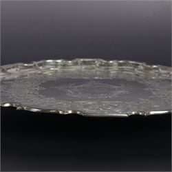 George II silver salver, of circular form with pie crust rim, with later floral and foliate decoration and presentation engraving to centre, upon three stepped feet, hallmarked William Peaston, London 1749, D30cm