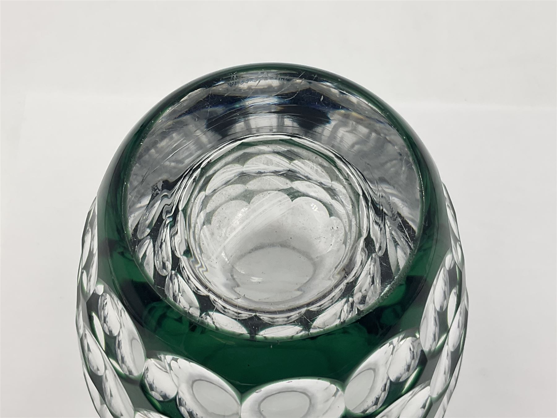 Val St Lambert style glass vase of shouldered ovoid form, cased in deep green over clear and heavily cut with repeat spherical pattern, indistinctly signed beneath ('Jac E. Dalmley'?), H15cm