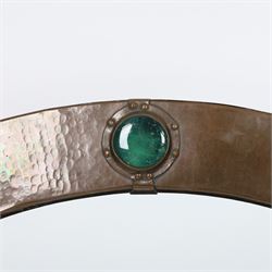 Liberty & Co, Arts and Crafts hammered copper framed oval wall mirror, mounted by four turquoise Ruskin cabochon roundels, with ivorine maker's label verso