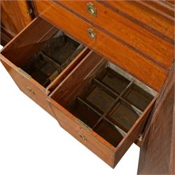 Fine Regency mahogany breakfront library bookcase, the stepped and moulded cornice over four astragal glazed doors enclosing adjustable shelves, the projecting central lower section with a pair of panelled doors enclosing three graduated drawers with brass inset handles above two deep zinc-lined cellarette compartments, flanked by panelled cupboard doors enclosing shelves, the figured mahogany fronts with ebony line inlay, on moulded plinth bases