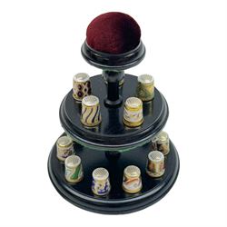 Collection of fifteen Royal Crown Derby thimbles upon an ebonised display stand, together with Royal Crown Derby candle snuffer in Imari pattern 1128