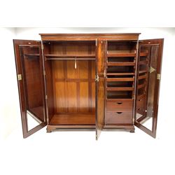 Edwardian mahogany inlaid and cross banded triple wardrobe, projecting cornice above linen slides above two drawers, bevel edge mirror and fitted interior, brass hinge and handles, shell carved shaped bracket supports
