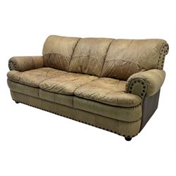 Contemporary three-seat sofa, upholstered in stitched brown leather with brass studwork decoration, rolled back and arms, raised on turned supports