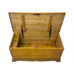 Late 19th century stripped pine blanket box, rectangular hinged lid enclosing main compartment with fitted candle box, wrought iron strap hinges and lock, black-painted side handles, on a shaped plinth base