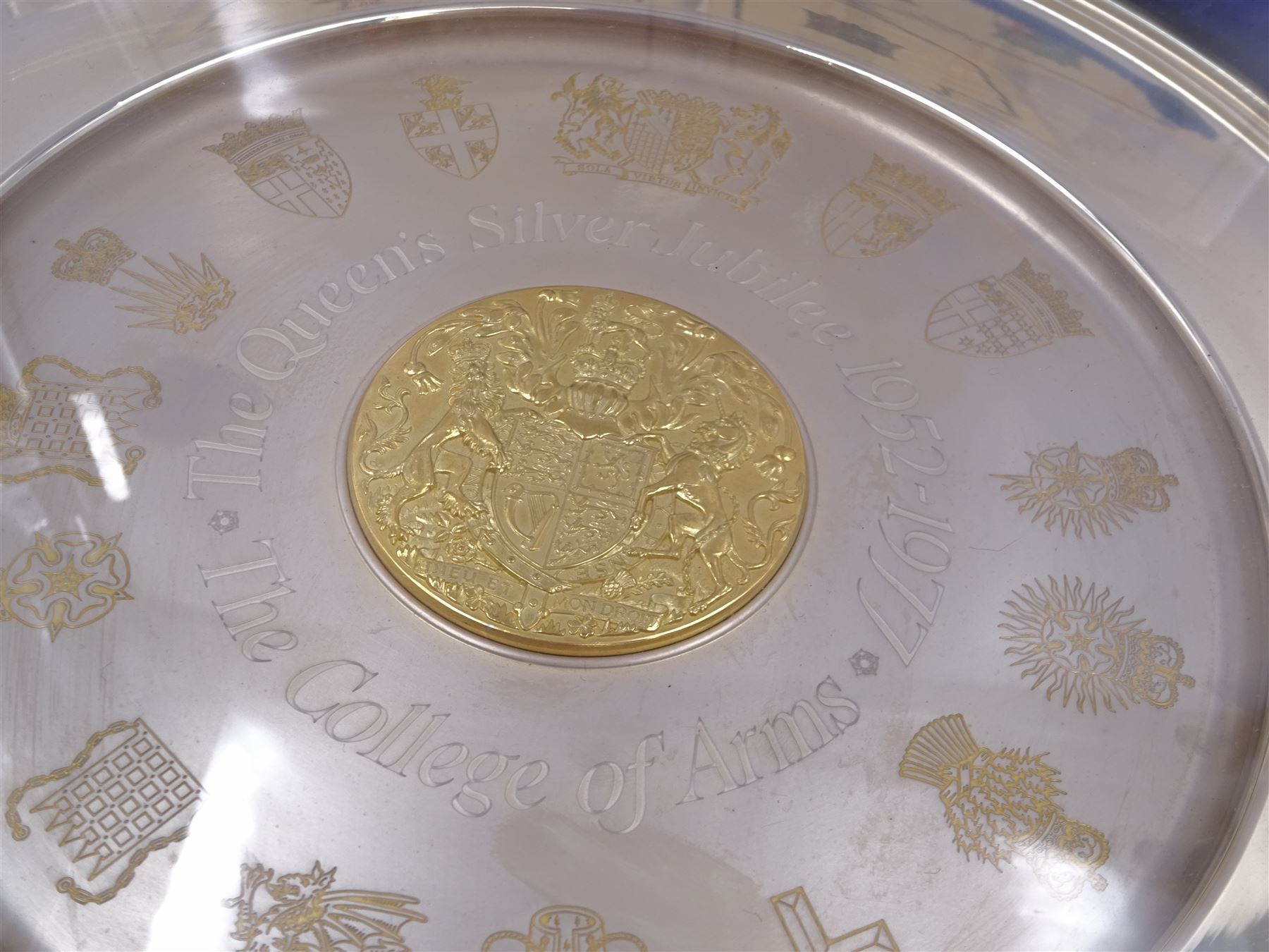 Modern limited edition silver The College of Arms plate to commemorate the The Queen's Silver Jubilee, the plain circular plate with central 24ct gold plated plaque depicting the Royal Arms, bordered by engravings of The College of Arms and the Kings Arms etc, by Danbury Mint, hallmarked Yorkshire Mint, Birmingham 1977, number 350/2500, in original fitted box with paperwork, D26,5cm, 