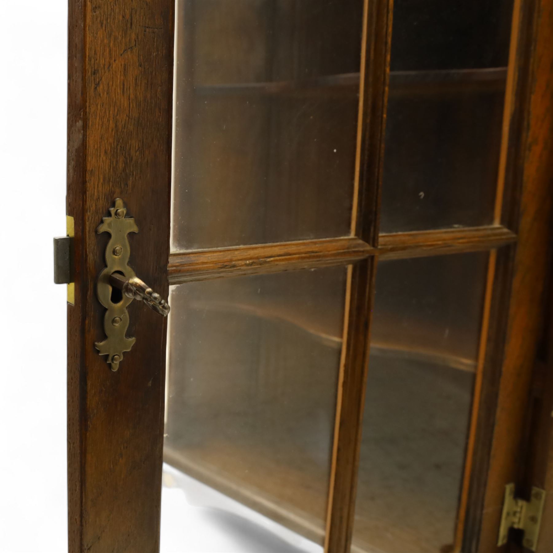 Early 20th century oak wall-mounted corner cabinet, moulded cornice above a single glazed door with six-panel astragal glazing, fitted interior with two shaped shelves