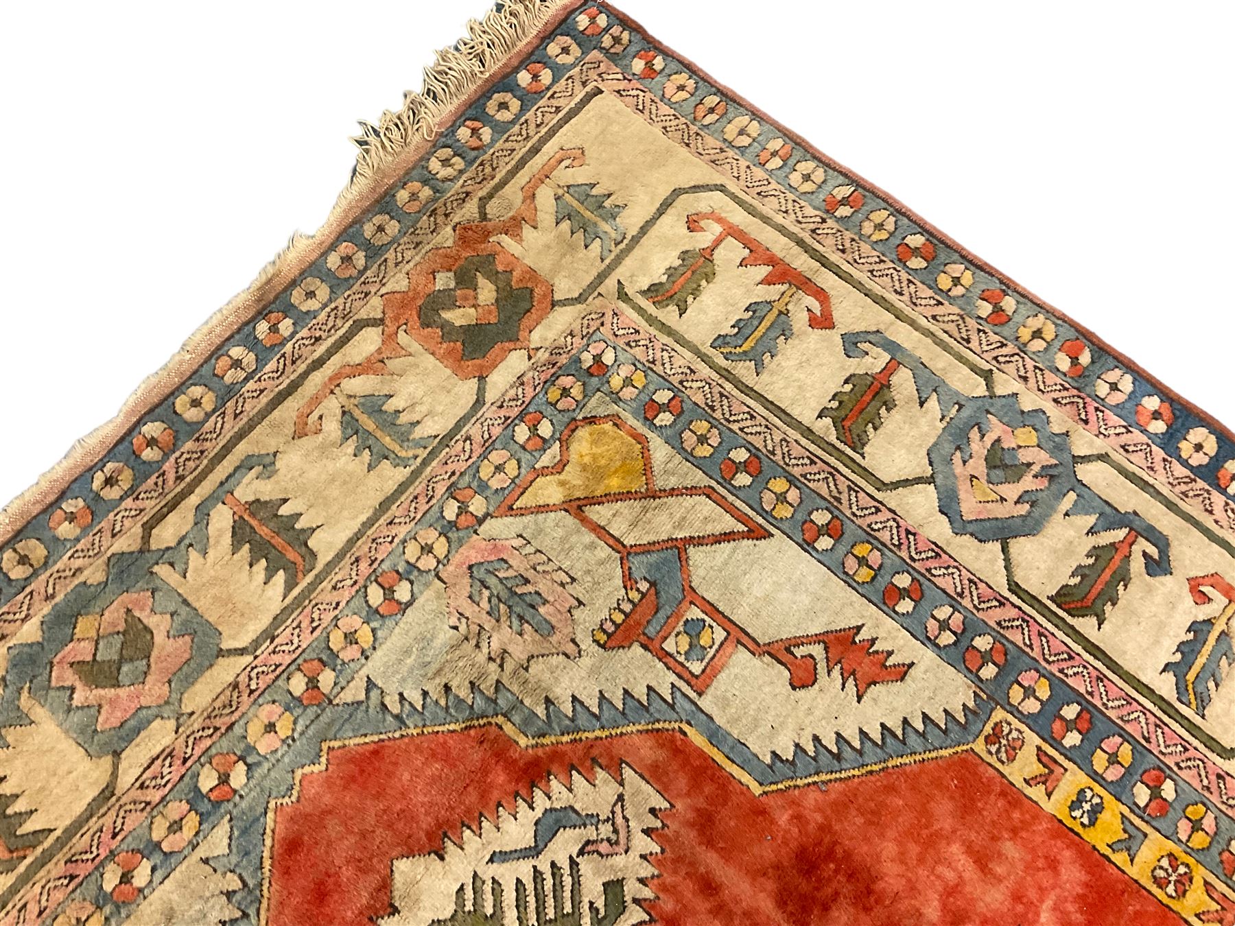 Anatolian Turkish ivory ground carpet, the central geometric pole medallion within an amber field, the guarded border decorated with stylised plant motifs surrounded by bands of repeating flower heads