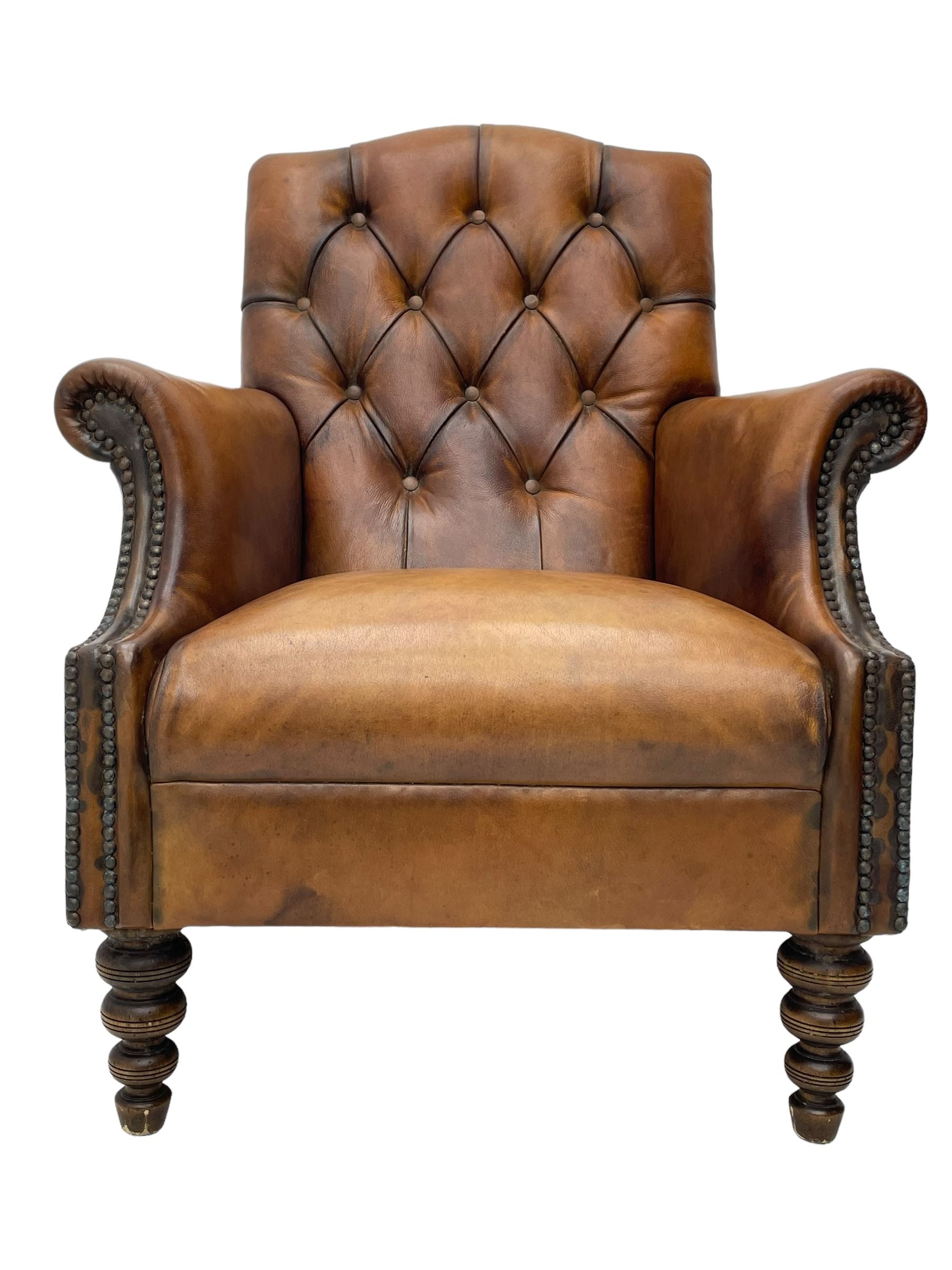 Laura Ashley - hardwood-framed armchair, traditional shape with arched cresting rail over rolled arms, upholstered in buttoned brown leather with studded work, on turned front feet (W76cm, W95cm, D84cm); together with matching rectangular footstool (53cm x 34cm, H29cm)