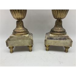 Pair of 19th century gilt metal twin handle urns, raised upon stepped marble bases, H36cm