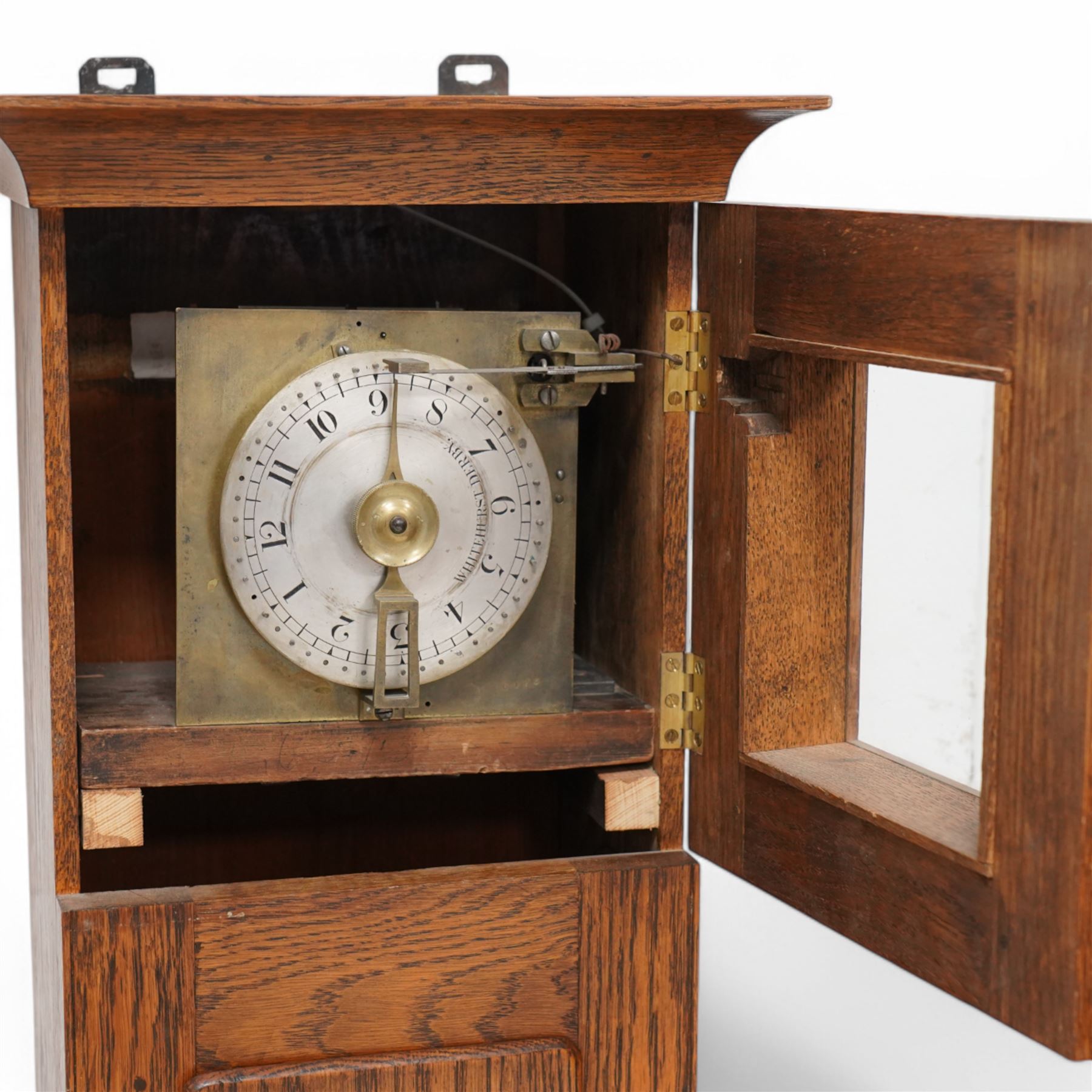 John Whitehurst of Derby- late 19th century oak cased wall hanging Noctuary or night watchman's wall clock, in a rectangular case with a moulded and glazed door to the dial and full length trunk door, with a silvered circular dial and a brass indicating pointer, Arabic numerals and quarter hour track with steel time recording pins, four wheel chain driven going train. No pendulum,chain or weight.    
John Whitehurst is one of the most prolific makers of these distinctive early type of night watchman's clocks, used predominantly in industrial premises, factories and mills in the north west of England during the 19th century.