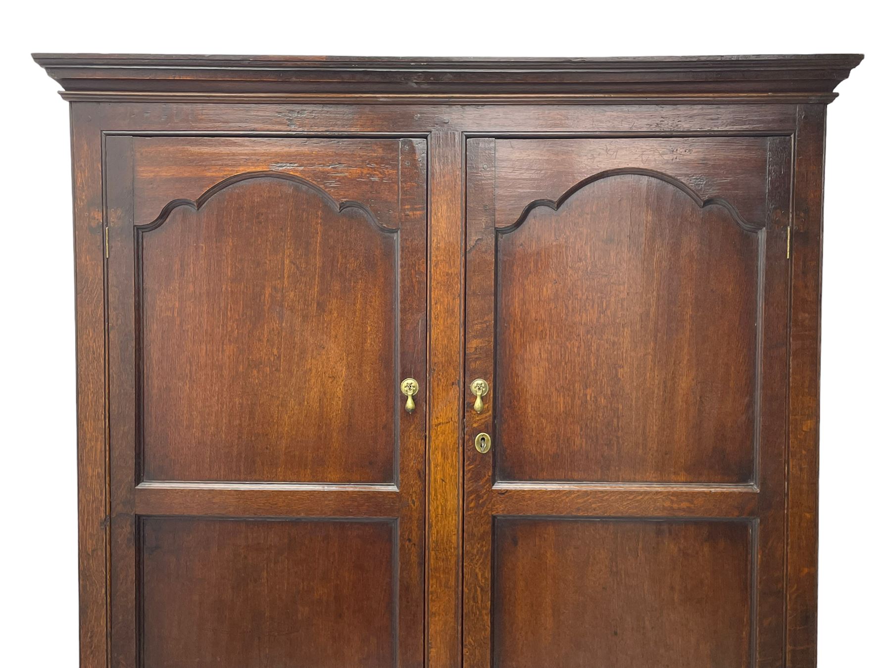 George III oak livery cupboard, projecting moulded cornice over two panelled doors, the upper panels within stepped ogee and arched moulded frame, the interior fitted with a single row of wooden hooks, two short and one long drawers, on bracket and return skirted base 