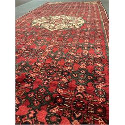 Persian red ground runner rug, central pale floral medallion and corners, floral and shaped field