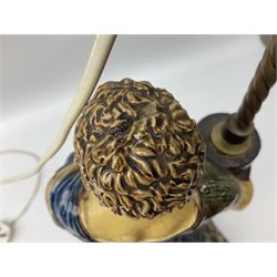 Composite table lamp modelled as a Roman Emperor donning blue robes, upon quatrefoil base modelled with rams heads and winged cherubs, H56cm excl fitting