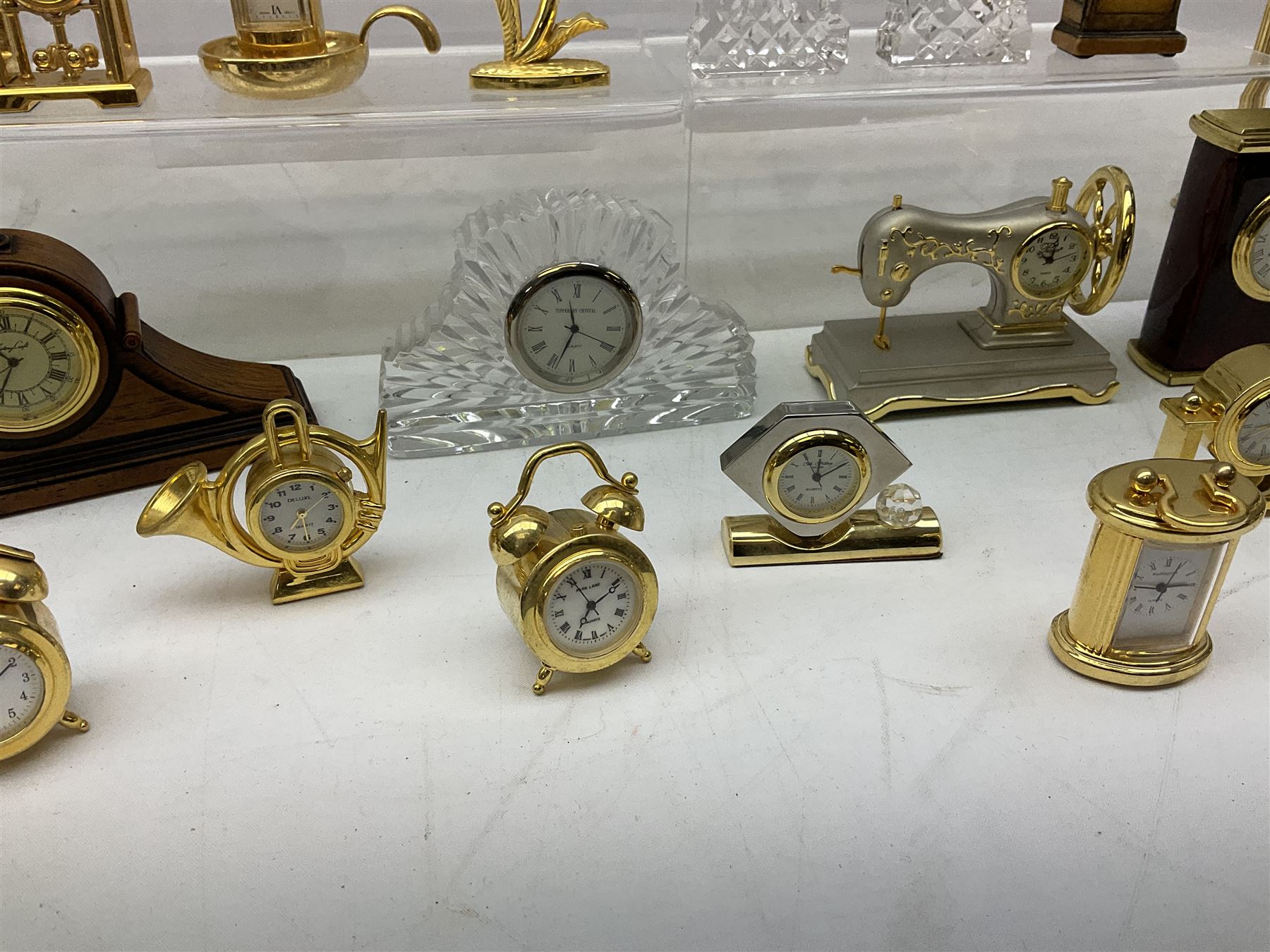 Collection of miniature clocks, predominantly with quartz movements, to include example modelled as an armchair, Edinburgh crystal glass example, clock modelled as a flower, sewing machine etc