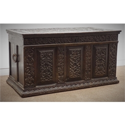  18th century and later oak coffer with three panelled front, all over carved with strap work, scrolls and stylised foliage, iron loop handles, W125cm, H65cm, D63cm  