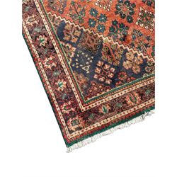Persian Joshaghan rust ground rug, stepped lozenge medallion surrounded by repeating foliate lozenge motifs, the border decorated with stylised plant motifs, within geometric guard stripes
