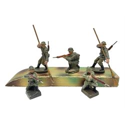 German Elastolin camouflaged wooden boat with two soldier paddlers L24cm; together with three similar figures of soldiers kneeling firing a rifle, one marked Leyla (6)