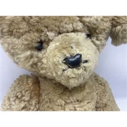 1950s sheepskin plush covered teddy bear with musical movement, the revolving head with applied eyes, leather nose and stitched mouth, jointed limbs with leather pads H50cm
