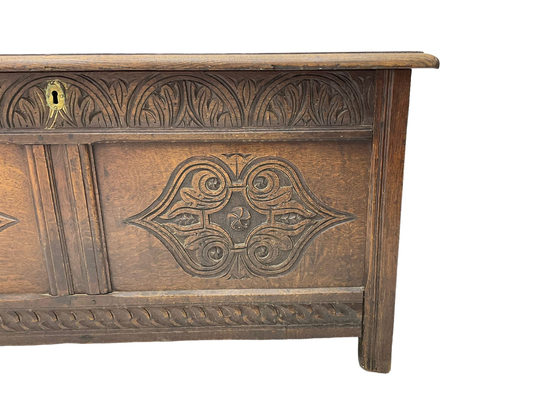 18th century oak blanket chest or coffer, rectangular hinged top with three panels and moulded edge, frieze carved with lunette and acanthus leaf decoration, two front panels carved with scrolling motif, raised on stile supports