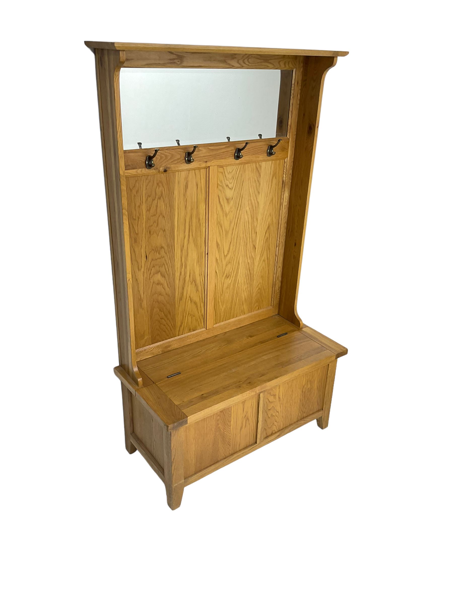 Oak mirror-back hall bench, projecting cornice, rectangular bevelled plate over four coat hooks, hinged box seat compartment with panelled front, on square tapering feet