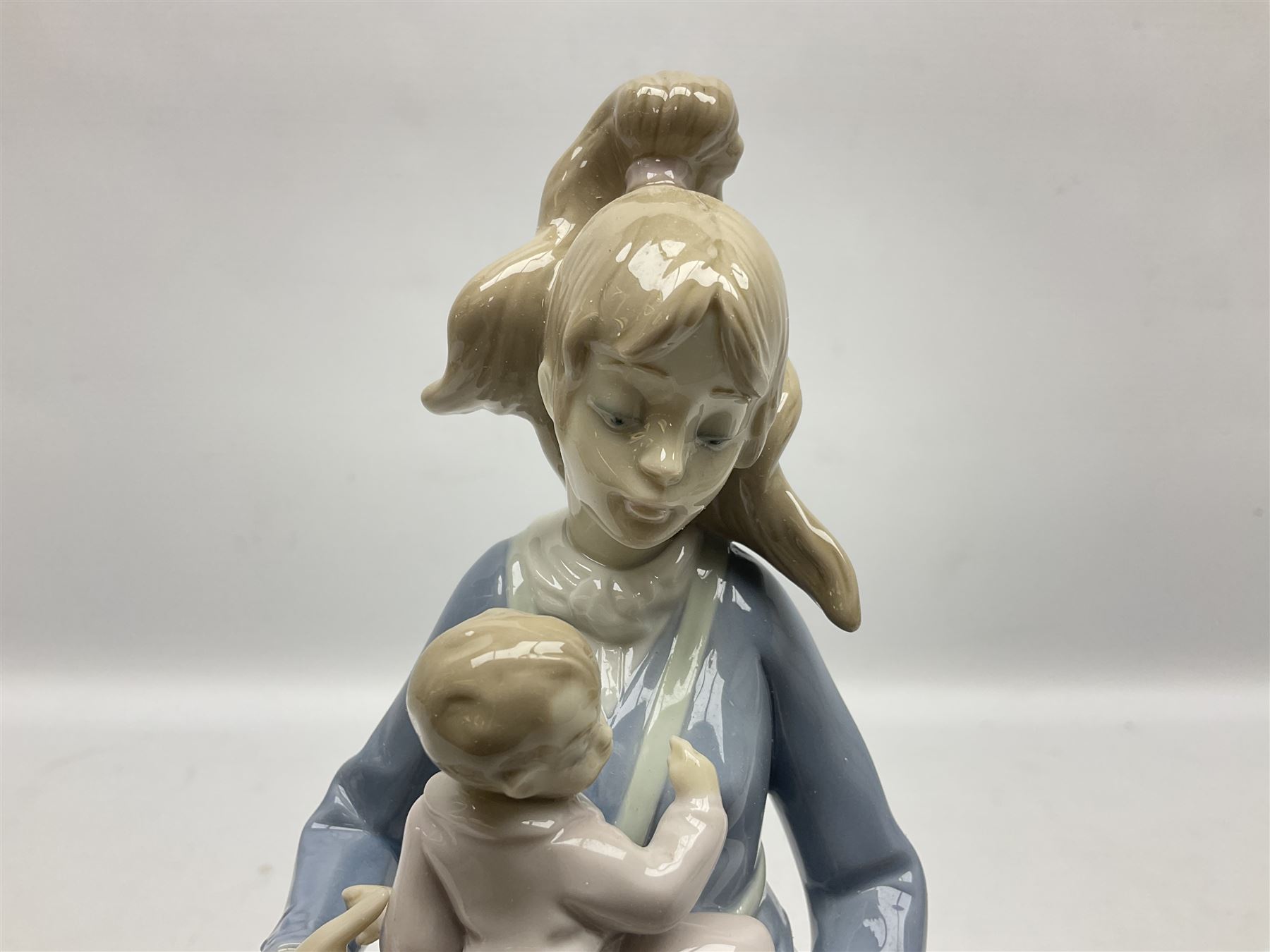 Three Lladro figures, comprising Modern Mother no 5873, Dropping the Flowers no 1285 and On the Beach no 1481, all with original boxes, largest example H30cm