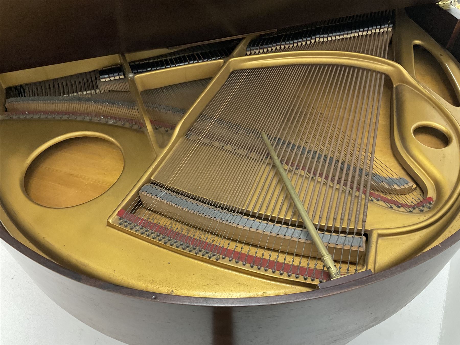 Early 20th century mahogany cased Strohmenger London baby grand piano, demi lune shape, over strung cast iron framed, raised on square tapered supports and castors 