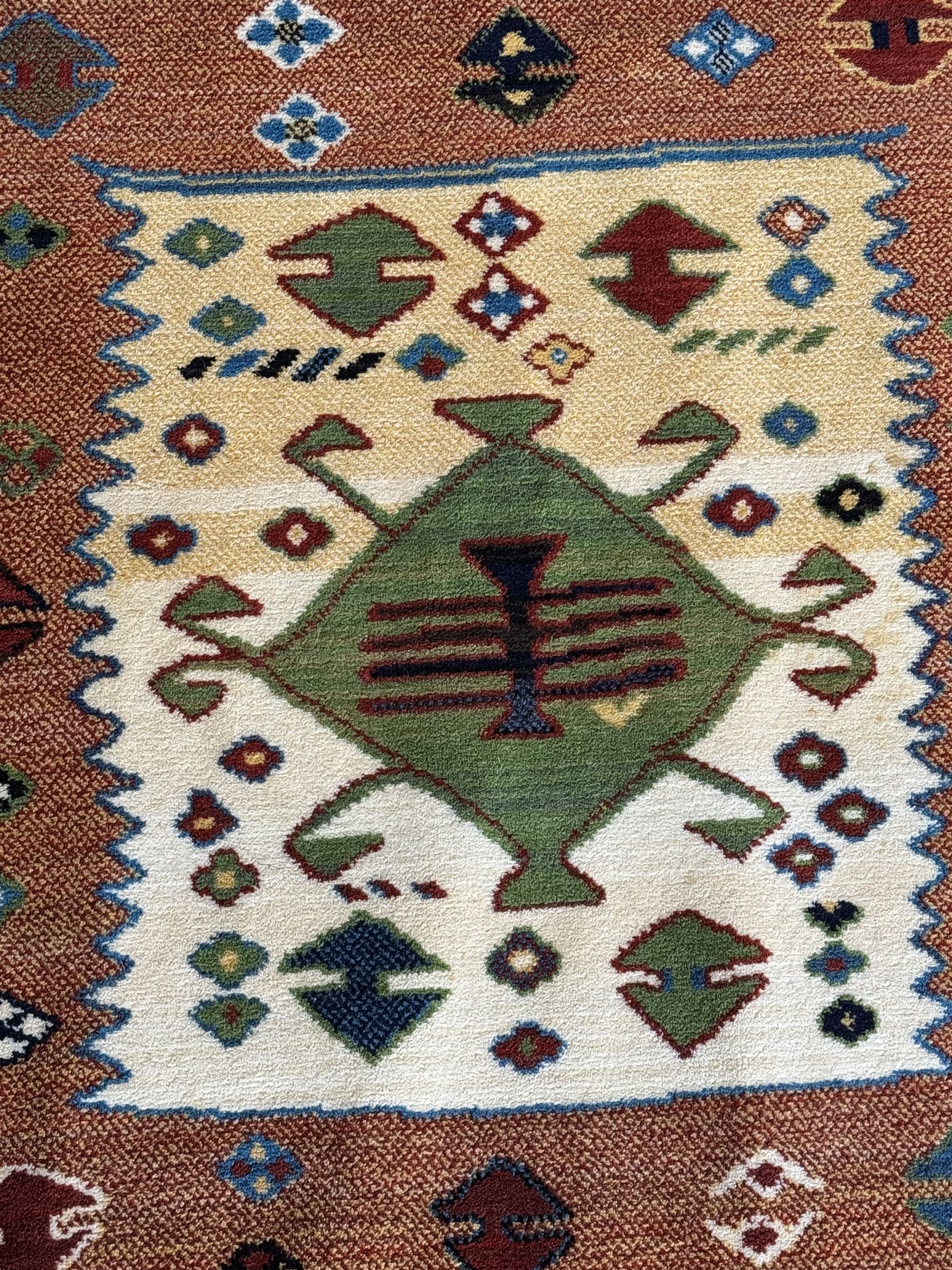 Late 20th century Louis De Poortere Belgian Shalamar wool ground rug, featuring a vibrant multi-coloured geometric design with stacked rectangular borders surrounding two central medallions, finished with fringed ends