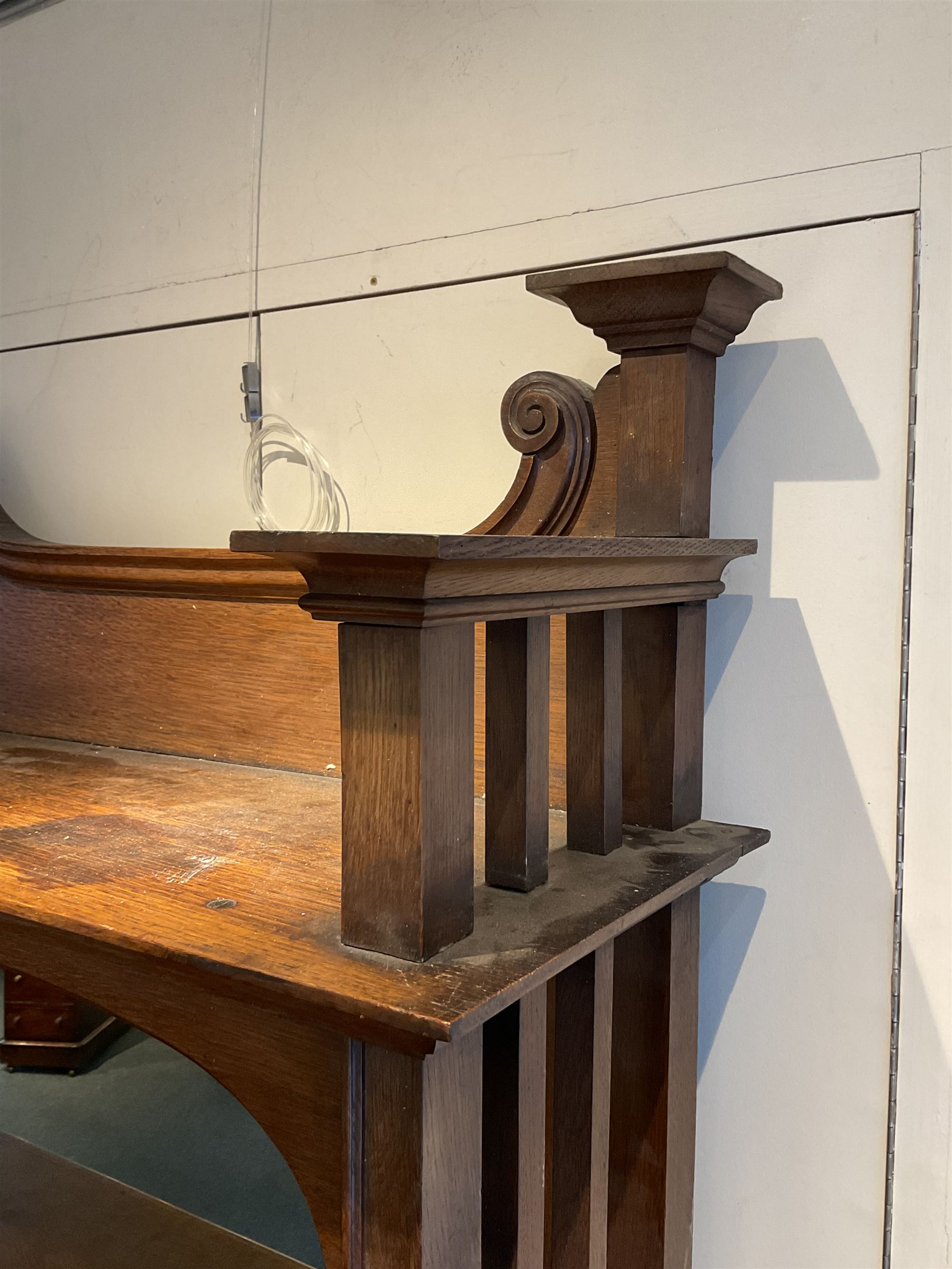 Late 19th century Arts & Crafts period oak mirror back sideboard, shaped bevelled mirror back carved with foliate scrolls and flower heads, down swept supports with elongated club-shaped uprights, moulded rectangular top over two drawers and three cupboards, the drawer fronts with copper handles decorated with sailing ships, panelled doors carved with mythical beasts, flowerheads and foliage, on moulded block feet