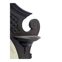 Early 20th century mahogany overmantel mirror, shaped broken pediment crest with open lattice panels, oval mirror plate flanked by scroll-carved bracket shelves

