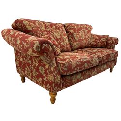 Traditional shape three seat sofa, upholstered in red fabric with trailing floral pattern, on turned front feet