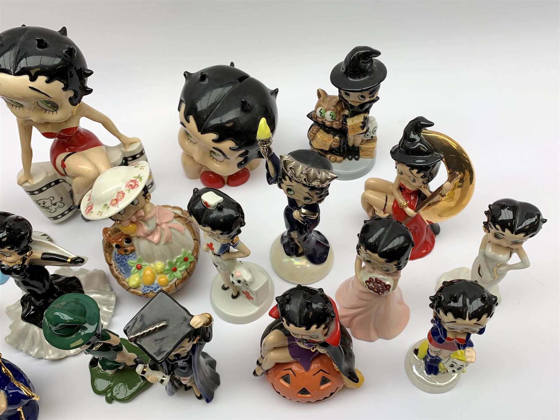 A collection of nineteen Wade Betty Boop figures, comprising Premier Movie Queen, 232/250, Premier Collection Snow Queen, 319/500, Premier Jubilee, 81/500, Bust Moneybank, 180/500, Showtime, 251/750, Lazy Daze, 479/750, Nurse, 153/2000, Biker, 125/750, Superstar, 368/750, St Patrick's, 26/750, Springtime 208/1000, Cheers Ten Years, 36/1250, Halloween Trick Or Treat, 505/1000, Halloween 2002, 73/750, Liberty Figurine, 460/1000, Material Girl, 303/, and Graduate, 233/500, all with accompanying certificates, and three examples without certificates, Rainy Days, Rose, and Trick of Treat 2003.