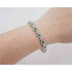 18ct white gold emerald and diamond bracelet, fifteen oval cut emeralds, each surrounded by ten round brilliant cut diamonds and spaced by a further four diamonds, stamped, total emerald weight approx 3.30 carat, total diamond weight approx 2.10 carat