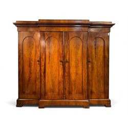 19th century mahogany break-fronted quadruple wardrobe, stepped and moulded projecting cornice over four arch panelled doors, moulded plinth base on blocks 