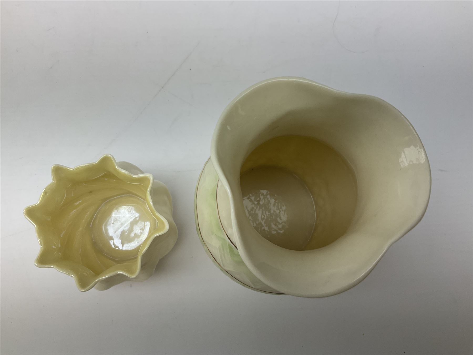 Quantity of Belleek ceramics to include mid-late 19th century jug moulded with green man mask and foliage, date code stamp for 1863-1890, together with later Belleek cornucopia shape vase, jug and other vases together with a Belleek style shell dish raised on branches, tallest H19cm