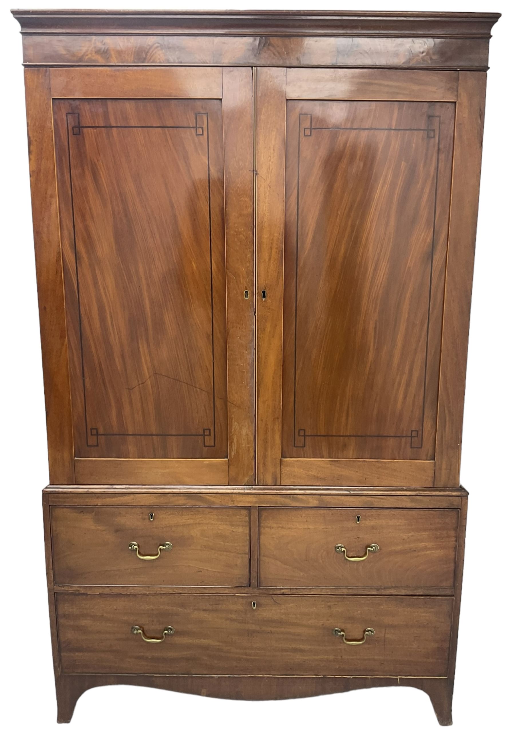 19th century mahogany linen press, projecting moulded cornice over figured frieze, enclosed by two panelled doors with geometric stringing, fitted with two short and one long cock-beaded drawers, on shaped apron and splayed bracket feet