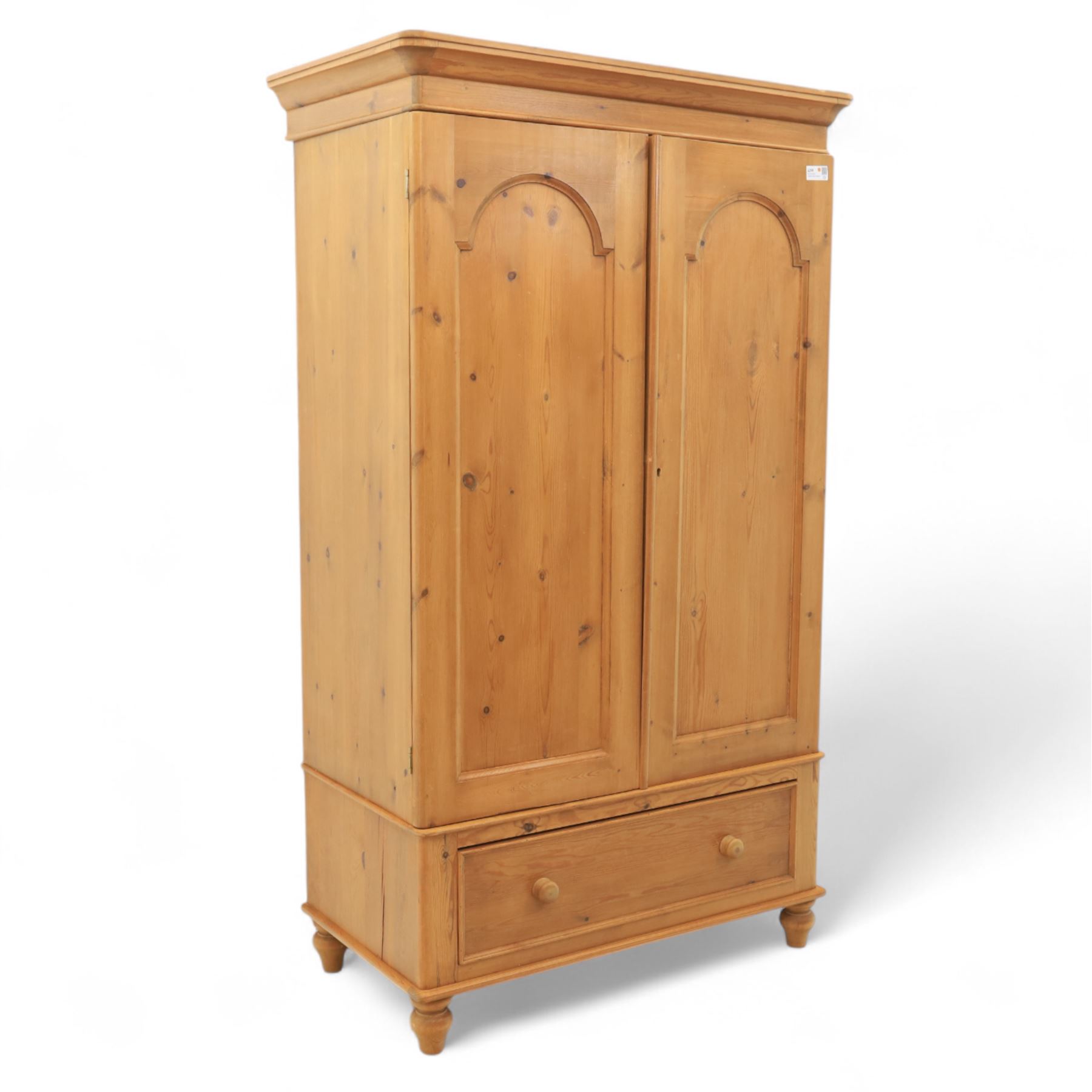 Two contemporary traditional-style wardrobes, projecting plain cornice above two arched moulded panel doors, above a full-width drawer fitted with turned wooden handles, raised on turned bun feet